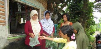 Supartini (Baju merah kerudung krem) sedang melayani tetangga yang belanja di warung sederhananya. Selain berjualan, Supartini aktif menjadi kader kesehatan reproduksi ‘Aisyiyah di Cirebon
